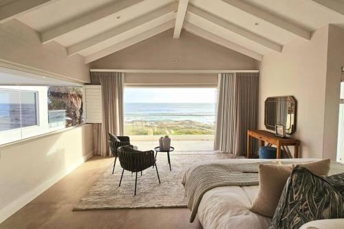 a bedroom with a bed and a view of the ocean at Villa Swart in Stompneusbaai