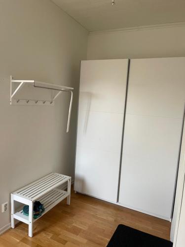 a room with a white refrigerator and a shelf at Gröna Huset in Torsby