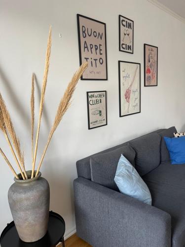 a living room with a gray couch and some pictures on the wall at Gröna Huset in Torsby