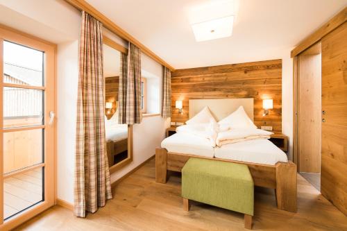 een slaapkamer met een bed en een groot raam bij Hotel Gasthof Erbhof Anderlhof in Leogang