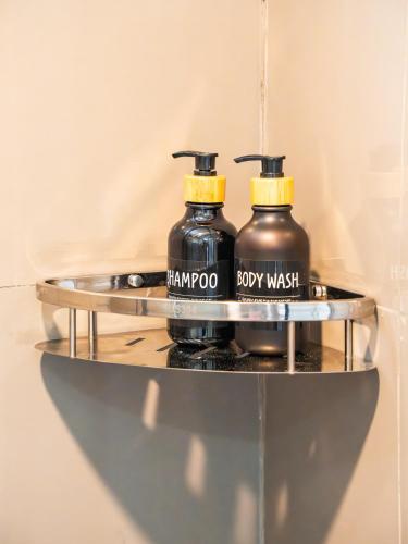 two black bottles on a metal shelf at La Pearl Mathiveri in Mathiveri