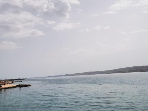 a body of water with a group of people on a pier at Kuća za odmor Tomislav in Trnovdc