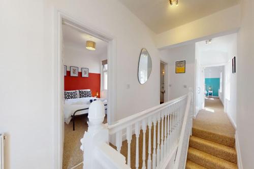 a white room with a bed and a staircase at City Centre - 2 Bed Apartment- Free Parking & Netflix in Cardiff