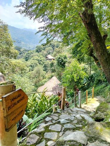 a sign for a hiking trail in the mountains at Minca Ecohabs Hotel in Minca