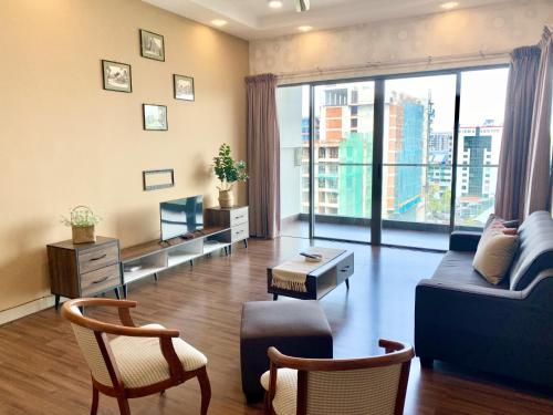 a living room with a blue couch and a large window at Deco Home @ Imago The Loft in Kota Kinabalu