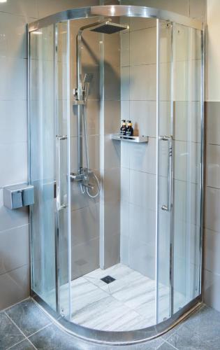 a shower with a glass door in a bathroom at La Pearl Mathiveri in Mathiveri
