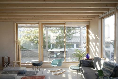 un salon avec un canapé et une grande fenêtre dans l'établissement Maison d'architecte à 7min de Paris, à Issy-les-Moulineaux