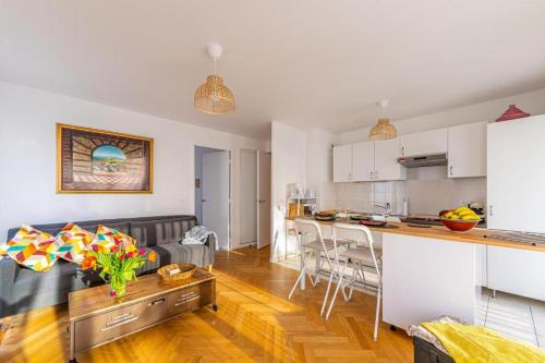 une cuisine et un salon avec un canapé et une table dans l'établissement Le Korrigan de Massy, à Massy