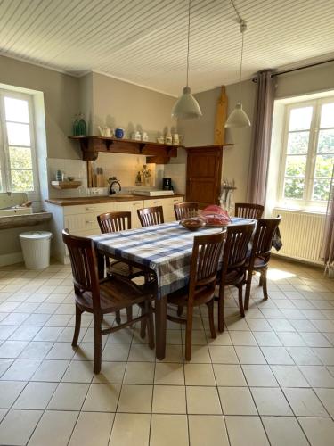 a kitchen with a dining room table and chairs at Maison de Famille Les Tourelles in Tour-de-Faure