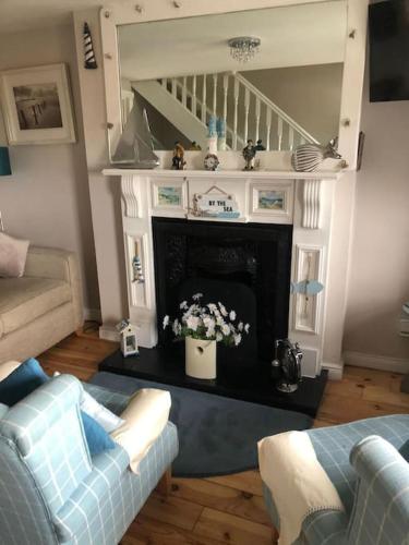 a living room with a couch and a fireplace at Promenade Cottage, Newcastle, County Down in Widows Row