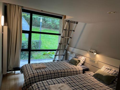 a bedroom with two beds and a ladder on the wall at Villa des Templiers - 20 min Brussels Airport in Wavre