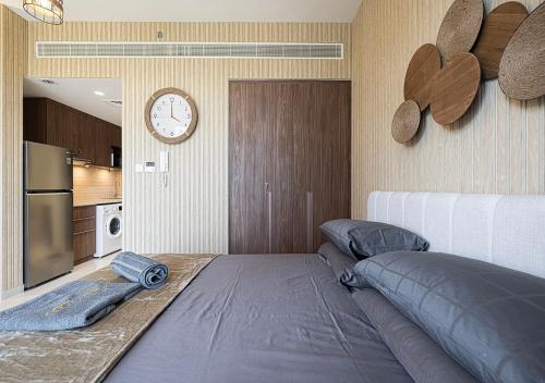 a room with a bed and a clock on the wall at Private Platinum Studio Apartment in Al Zahia, Sharjah in Ḩiz̧āyib az Zānah