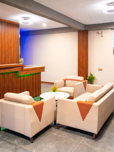 a waiting room with white couches and a stage at La Pearl Mathiveri in Mathiveri