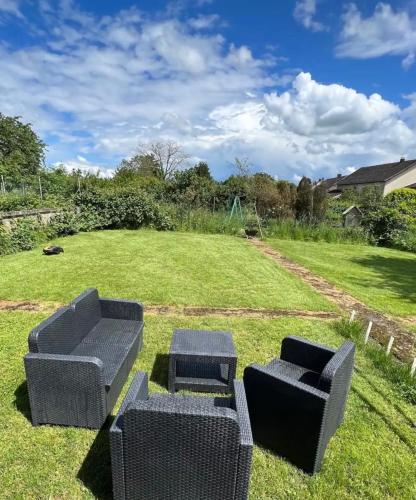 2 canapés assis sur l'herbe dans une cour dans l'établissement Guenviller Green Gem, à Betting-lès-Saint-Avold