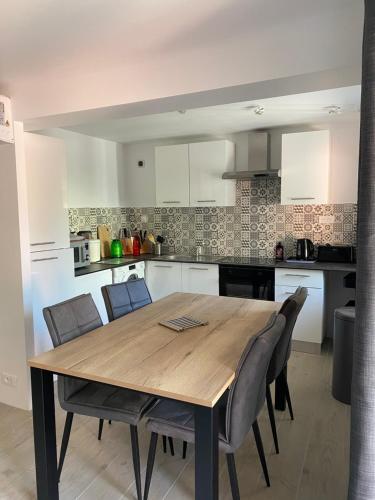 une cuisine avec une table et des chaises en bois dans l'établissement RDC-120m plage Agay-2ch, à Agay