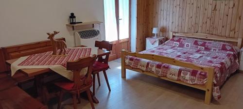 a bedroom with a bed and a table and chairs at Monolocale Il Capriolo - Abetone in Abetone