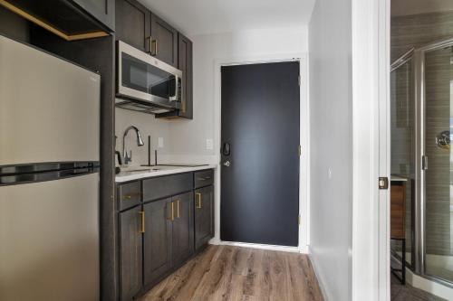 a kitchen with a sink and a microwave and a door at Cottage Suites in Middletown