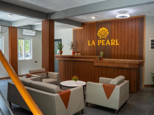 a waiting room with a la pearl sign on a wall at La Pearl Mathiveri in Mathiveri