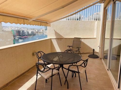 a balcony with a table and chairs on it at Duplex Penthouse in Sliema in Sliema
