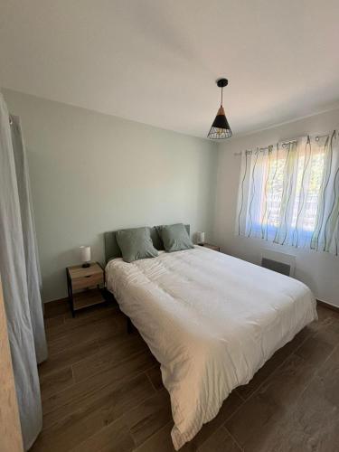 une chambre avec un grand lit blanc et deux fenêtres dans l'établissement La Villa d Isa, à La Motte