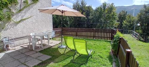 a patio with a table and chairs and an umbrella at Monolocale Il Capriolo - Abetone in Abetone