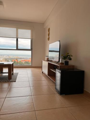 a living room with a desk and a television at Apart Moderno Vista al Mar in Comodoro Rivadavia