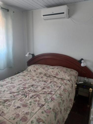 a bedroom with a bed with a floral bedspread at Carpedíem in Jaureguiberry