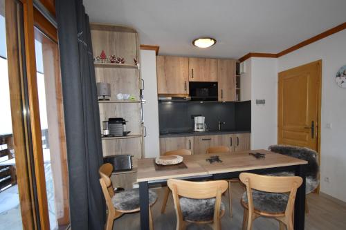 une cuisine avec une table et des chaises dans une pièce dans l'établissement VAUJANYLOCATIONS - Les Valmonts, à Vaujany