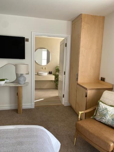 a bedroom with a bed and a bathroom with a mirror at Somerled House in Portree