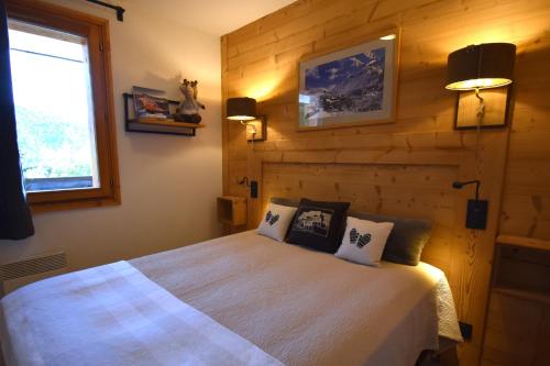 une chambre avec un lit dans un mur en bois dans l'établissement VAUJANYLOCATIONS - Les Valmonts, à Vaujany