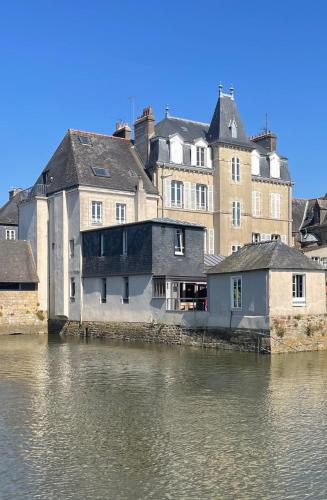 un groupe de bâtiments à côté d'une masse d'eau dans l'établissement Nuit sur le Pont 2, à Landerneau