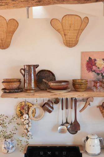 a kitchen shelf with utensils on a wall at Casa Pauseto in Bonnieux