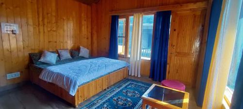a bedroom with a bed and a window at Vidhi homestay in Kulu
