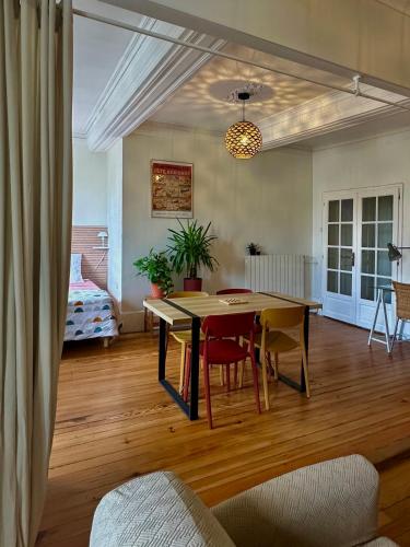 un salon avec une table et des chaises et un lit dans l'établissement Loft calme, lumineux 58 m2 en ville parking privé, à Montélimar