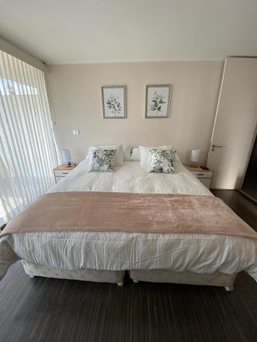 a bedroom with a large bed with two pillows at Kennedy Premium Apartments Colorado in Santiago