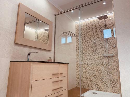 a bathroom with a shower with a sink and a mirror at A R Benjamín in Artana