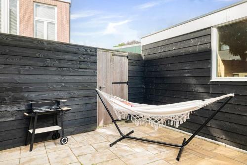 a hammock on a patio next to a wall at Chique Ibiza Zaandam in Zaandam