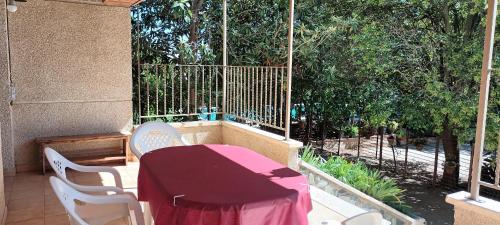 a red table and chairs on a balcony with trees at Marina in Lleida