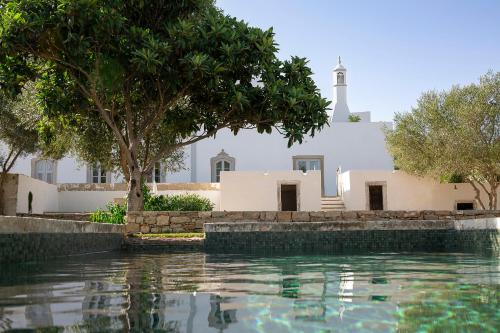 a church and a swimming pool in front of a building at Solar do Bisavô in Bordeira