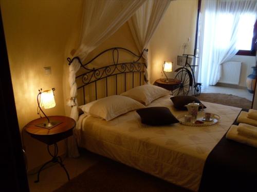 Garden Villa في يوانينا: غرفة نوم بسرير كبير مع طاولتين ومصباحين