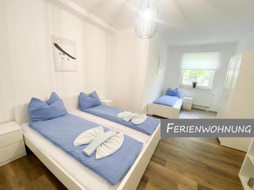 a bedroom with two beds with blue pillows at Hotel Zur Linde in Zschepplin