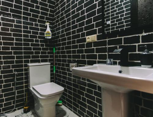 a bathroom with a white toilet and a sink at Cottage Sataplia in Kutaisi