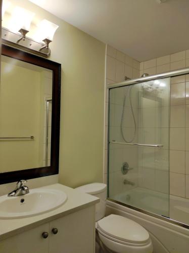 a bathroom with a toilet and a sink and a shower at Angela's Private Suites in Surrey
