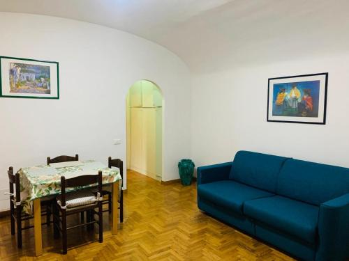 Una sala de estar con un sofá azul y una mesa. en Vacanze Romane Colosseo apartment, en Roma