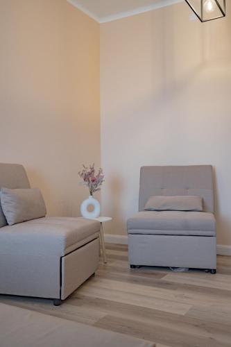 a room with two beds and a table with flowers at Appartamento Visconti by Rhospitality it in Rho