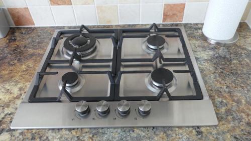 a stove top with four burners on a kitchen counter at Berrow Breeze in Burnham on Sea