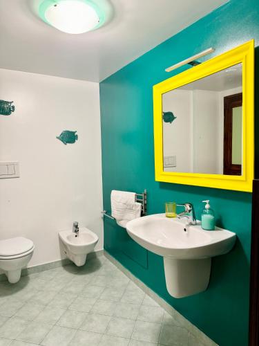 a bathroom with a sink and a toilet and a mirror at Qurchiti in Capo dʼOrlando