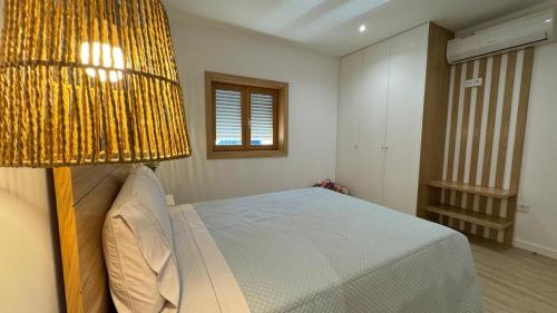 a bedroom with a bed with a yellow lamp at Refúgio do Espigueiro in Amarante