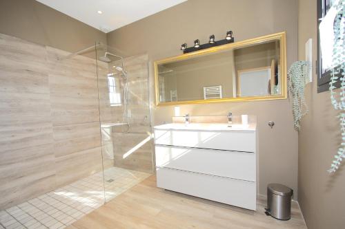 une salle de bain avec un lavabo blanc et une douche dans l'établissement Mas de Cartelan, à Paradou