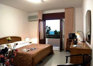 マリネッラにあるHotel Alcesteのベッドルーム1室(ベッド1台、デスク、窓付)